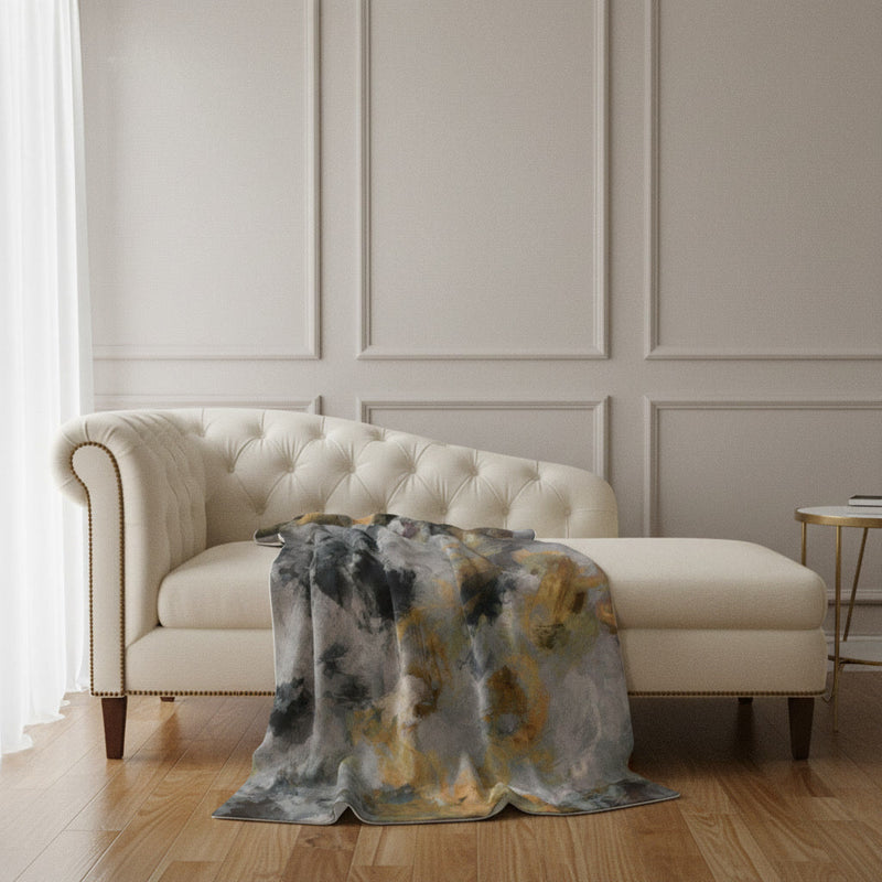 Terra Firma plush blanket draped over a cream tufted sofa